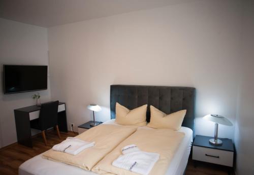 康斯坦茨维森塔勒尔伽尼酒店的一间卧室配有一张床,上面有两条毛巾