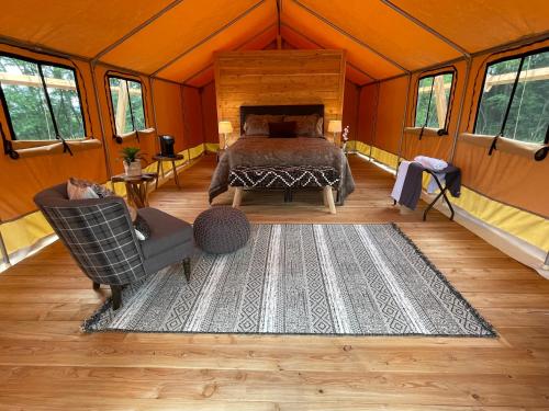 沃特金斯格伦Naturluxe & Stars的帐篷内的卧室,配有一张床和地毯
