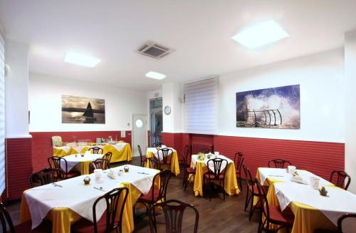 圣贝内代托-德尔特龙托中央酒店的用餐室配有桌椅和黄色餐巾