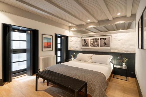 拉科鲁尼亚housingcoruña ART的一间卧室配有一张床和长凳