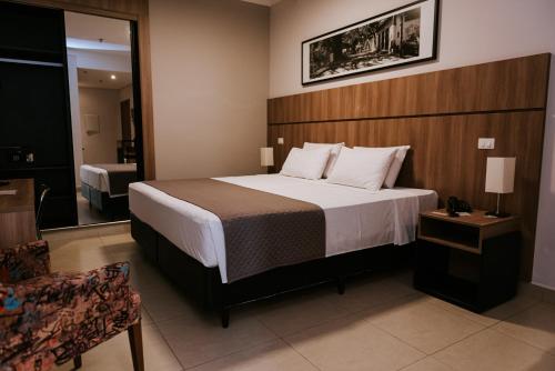 皮拉西卡巴欧西塔诺阿帕特酒店的配有一张床和一把椅子的酒店客房