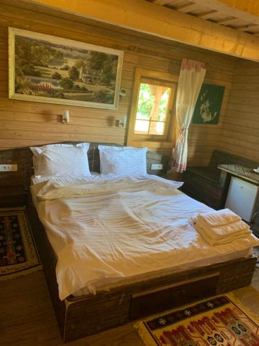 下维谢乌乡Căsuța Bunicilor的一间卧室配有一张带白色床单的大床