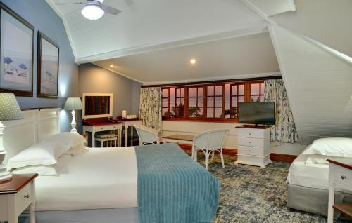 UmzumbePumula Beach Hotel的一间卧室配有一张床、一张书桌和一台电视