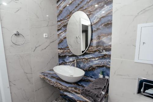 乌拉尔斯克LUX 6 МКР дизайнерская комфортная студия с панорамными дверьми и большой лоджией的一间带水槽和镜子的浴室