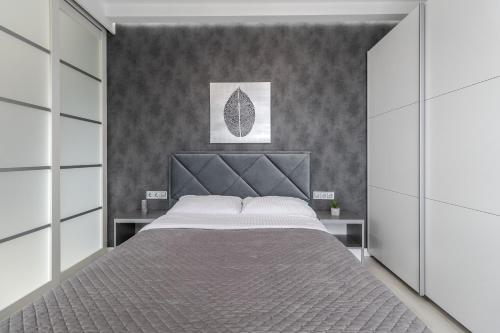 利沃夫Magic Apart 10的一间卧室配有一张大床和床头板