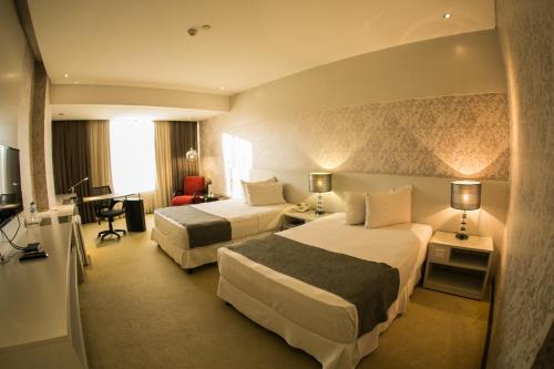 埃斯特城Nobile Hotel Convention Ciudad Del Este的酒店客房配有两张床和一张书桌