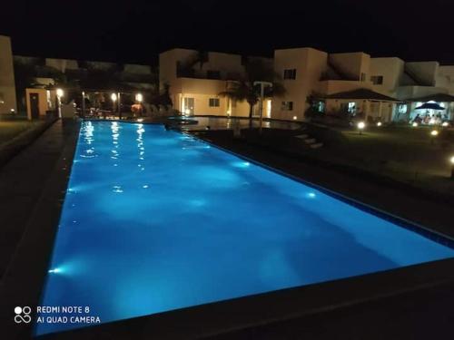 MaxaranguapePARAÍSO DE MARACAJAÚ - BEIRA MAR的夜间拥有蓝色灯光的游泳池