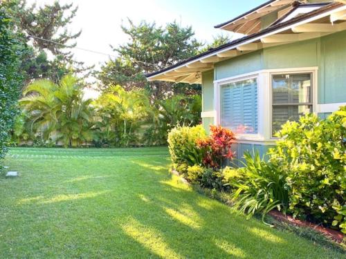 凯卢阿Modern Luxury Beach House Kailua的一座带绿草和鲜花的庭院