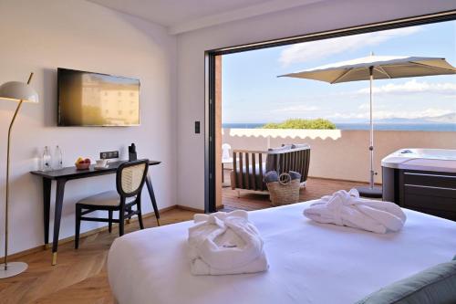利勒鲁斯Hôtel & Spa Rocabella的酒店客房设有一张床,享有海景。