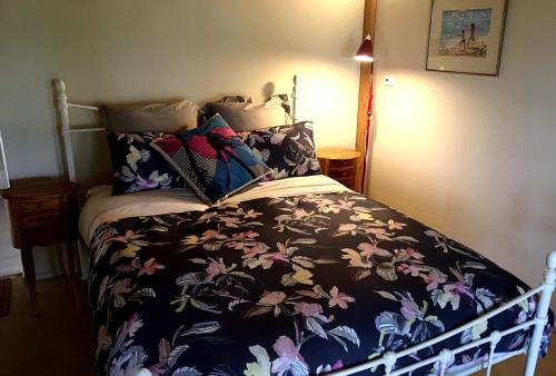FairhavenFrench Island Cottage的一间卧室配有一张带花卉床罩的床