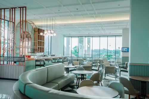美娜多Luwansa Hotel and Convention Center Manado的餐厅设有桌椅和窗户。