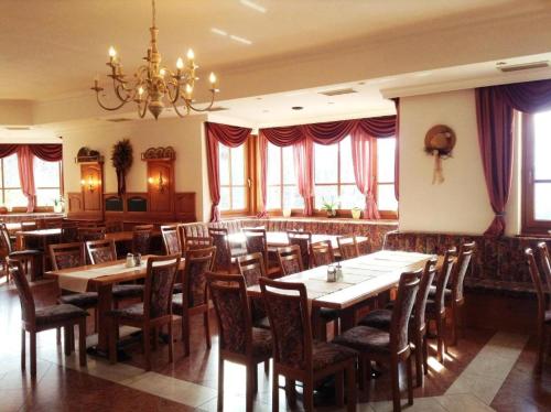 皮恩山口附近施皮塔尔欧博温格尔霍夫公寓式酒店的餐厅设有木桌、椅子和吊灯。