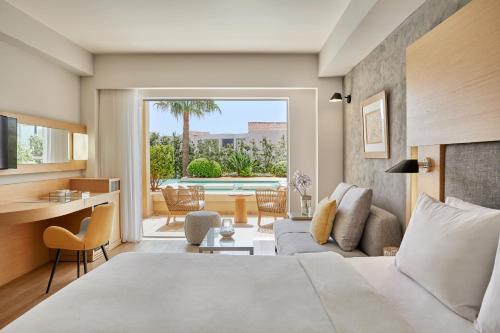 普拉塔尼亚斯Minoa Palace Resort的一间卧室设有一张床和一间客厅。