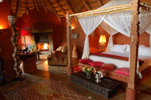 雾观迪马萌旅馆的一间卧室设有一张天蓬床和一个壁炉