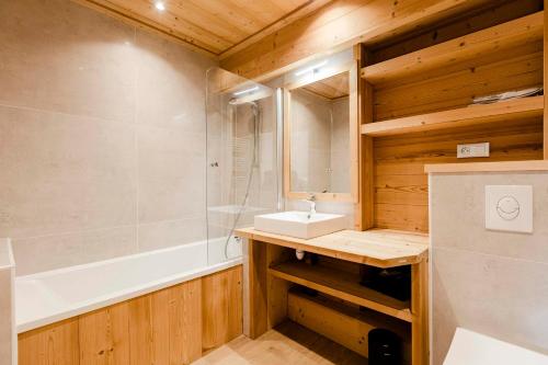 蒙热内夫尔La Plane, rénové en 2020, pied des pistes的浴室配有盥洗盆和浴缸。