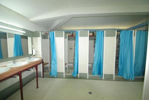 阿尔马达HI Almada - Pousada de Juventude的浴室设有2个水槽和蓝色的淋浴窗帘