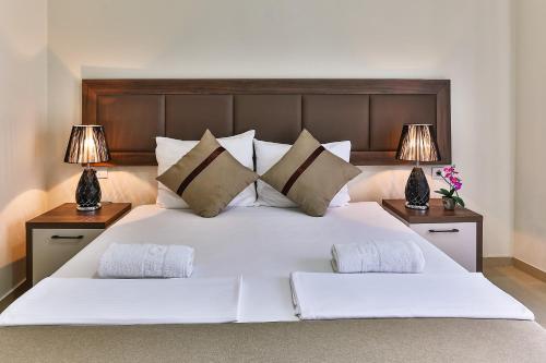 多布拉沃达Atlantic sobe的一间卧室配有一张带两盏灯的大型白色床。