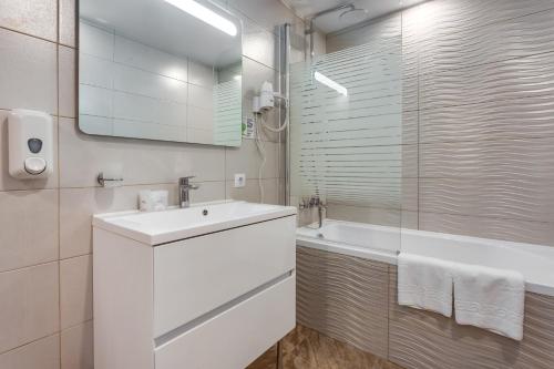 切尔诺莫斯克Optima Collection Miramar Chornomorsk的白色的浴室设有水槽和浴缸。