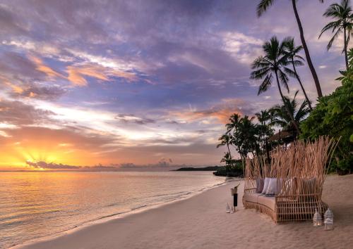 瓦阿Shangri-La Yanuca Island, Fiji的海滩上长着沙发,棕榈树,日落