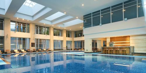 宁波宁波港城华邑酒店的一座大型游泳池,位于一座带窗户的建筑内