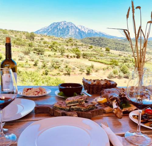 RoshnikAlpeta Agrotourism & Winery - Roshnik , Berat的餐桌,带餐盘和酒杯