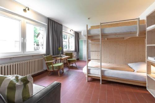 马莱斯韦诺斯塔FinKa的卧室配有两张双层床和一张桌子及椅子