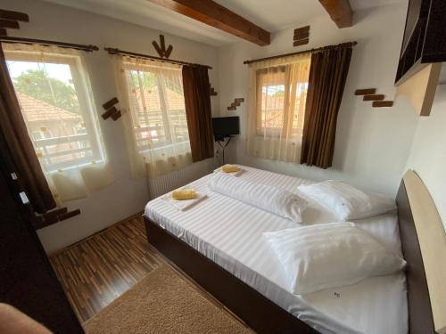 克尔茨什瓦拉乡Casa Floare de Colt的一间卧室配有一张带白色床单和窗户的床。
