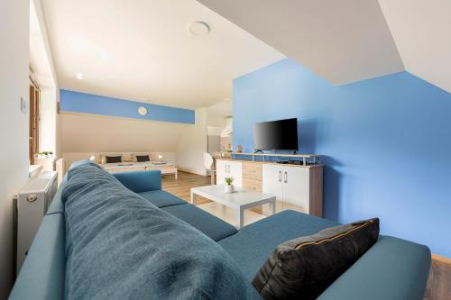 班斯卡比斯特里察Apartmaji Rupnik的客厅配有蓝色的沙发和桌子