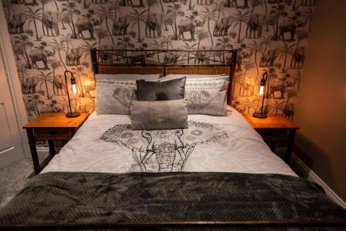 奥马Adorable First Floor 1-bedroom Loft with decking的一间卧室配有一张带两张桌子和两盏灯的床。