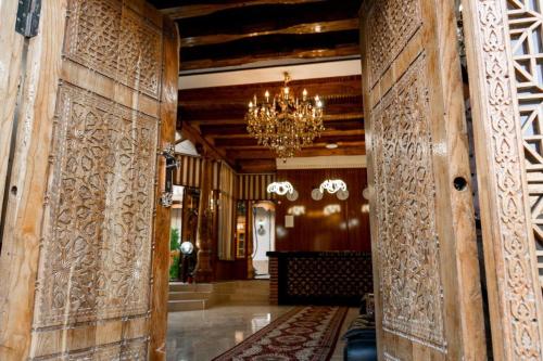 布哈拉Grand Nodirbek Boutique Hotel的走廊设有木墙和吊灯