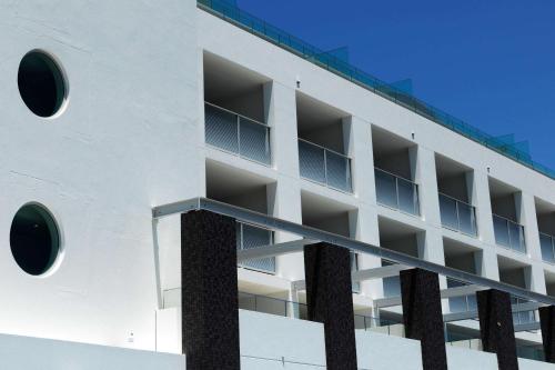 悉尼邦迪QT公寓式酒店的白色的建筑,侧面设有圆形窗户
