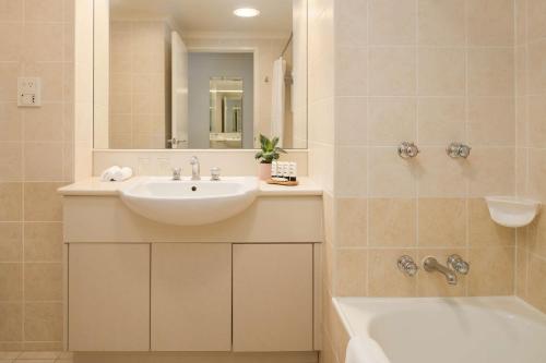 保尔罕希尔斯Rydges Norwest Sydney的浴室配有盥洗盆、浴缸和盥洗盆