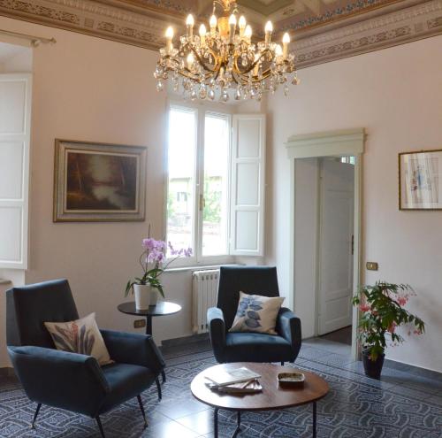 比萨Le Muse的客厅配有椅子和吊灯。
