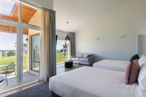 奥克兰Rydges Formosa Auckland Golf Resort的酒店客房设有两张床和一个阳台。