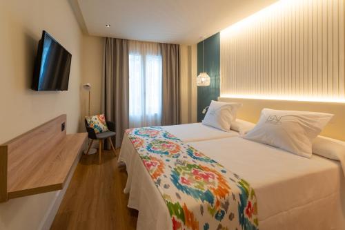 内尔哈La Puerta de Nerja BOUTIQUE - Adults Recommended的配有一张床和一台平面电视的酒店客房