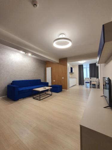 康斯坦察Aparthotel Nevada - Apartamente的客厅配有蓝色的沙发和桌子