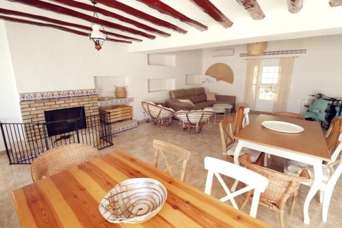 TinajerosMeravella Casa Rural的客厅配有桌子和壁炉