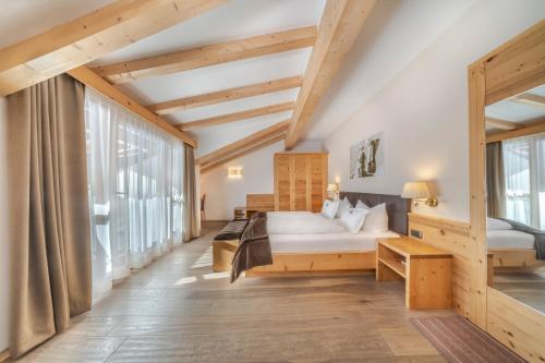 塞尔瓦迪加尔代纳山谷德拉赛斯小木屋酒店的一间卧室设有一张床和一个大窗户
