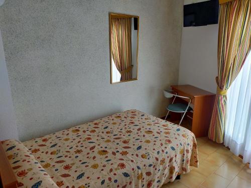 陶斯特Hostal Casa Pepe的一间卧室配有一张床、镜子和一张书桌