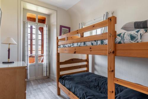 阿罗芒什莱班Maison avec beau jardin - Centre ville d'Arromanches的一间卧室配有两张双层床和一张书桌
