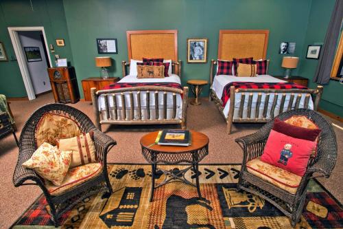 奥格登斯堡Sherman Inn的一间客房配有两张床、两把椅子和一张桌子
