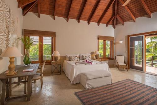 蓬塔卡纳Lake front villa with open design in luxury resort的卧室配有一张床和一张桌子及椅子