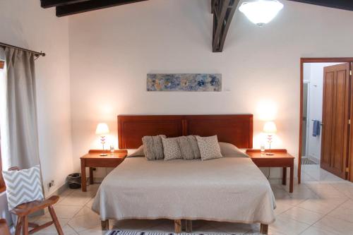 多洛雷斯-伊达尔戈La Capilla Hotel的一间卧室配有一张带两张桌子和两盏灯的床。