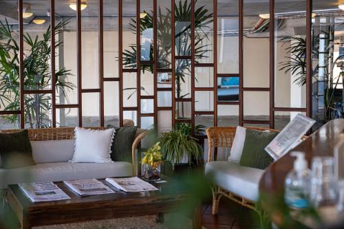 拜伦湾海滩度假酒店的一间设有两张沙发、一张桌子和植物的房间