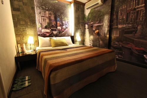 马尼拉欧洲电信北艾莎酒店的一间卧室配有一张壁画床