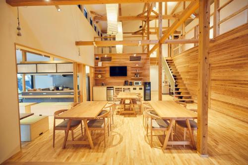 福生市ゲストハウス酒坊多満自慢的一间带木桌和楼梯的用餐室