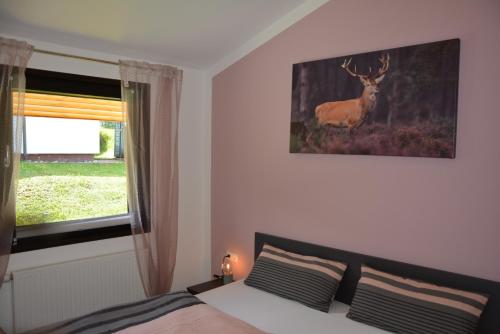 EichbachFerienhaus Starenweg 6的卧室配有一张床,墙上挂着鹿