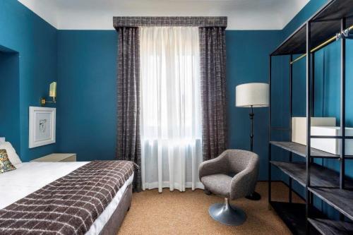 佛罗伦萨4F Boutique Hotel Florence的卧室配有床、椅子和窗户。