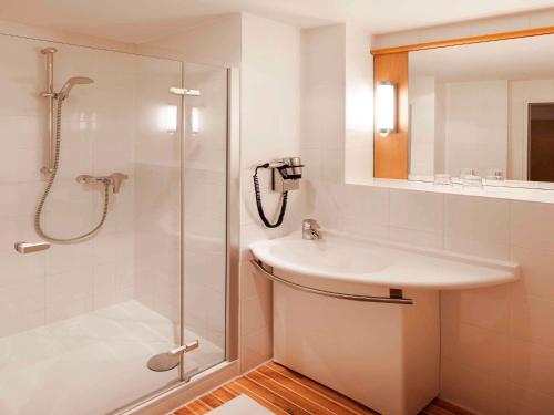 纽伦堡纽伦堡老成宜必思酒店的白色的浴室设有水槽和淋浴。