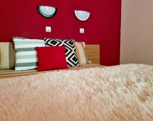 普雷代亚尔Pensiunea Don Sergio的一张带枕头和红色墙壁的床